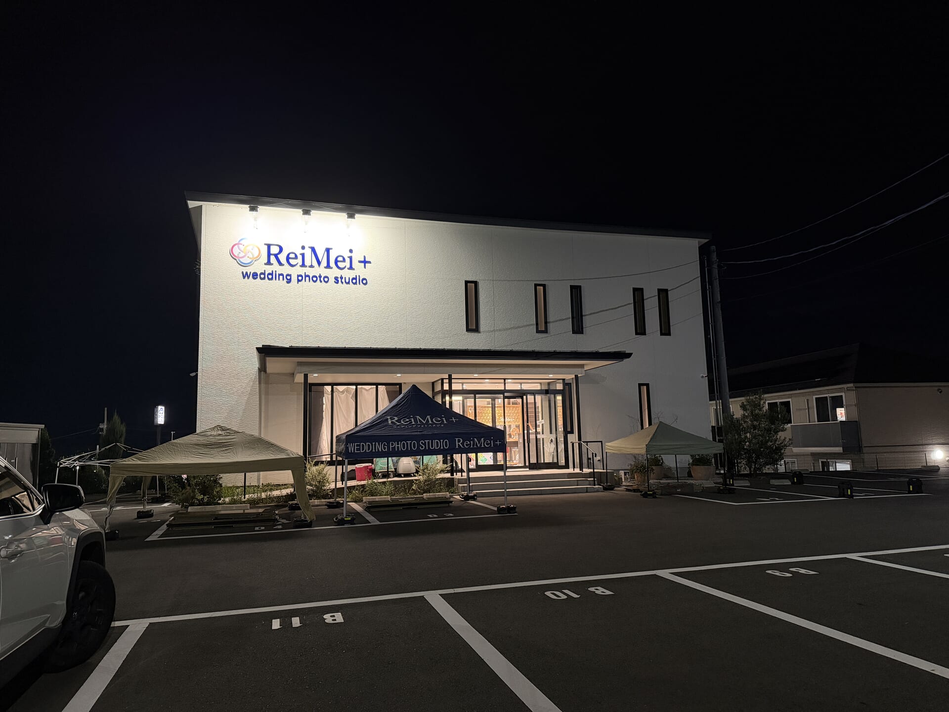 夜のReiMei+スタジオ外観。明日のイベントに向けてテントを設営し、ファッションショーのリハーサル中